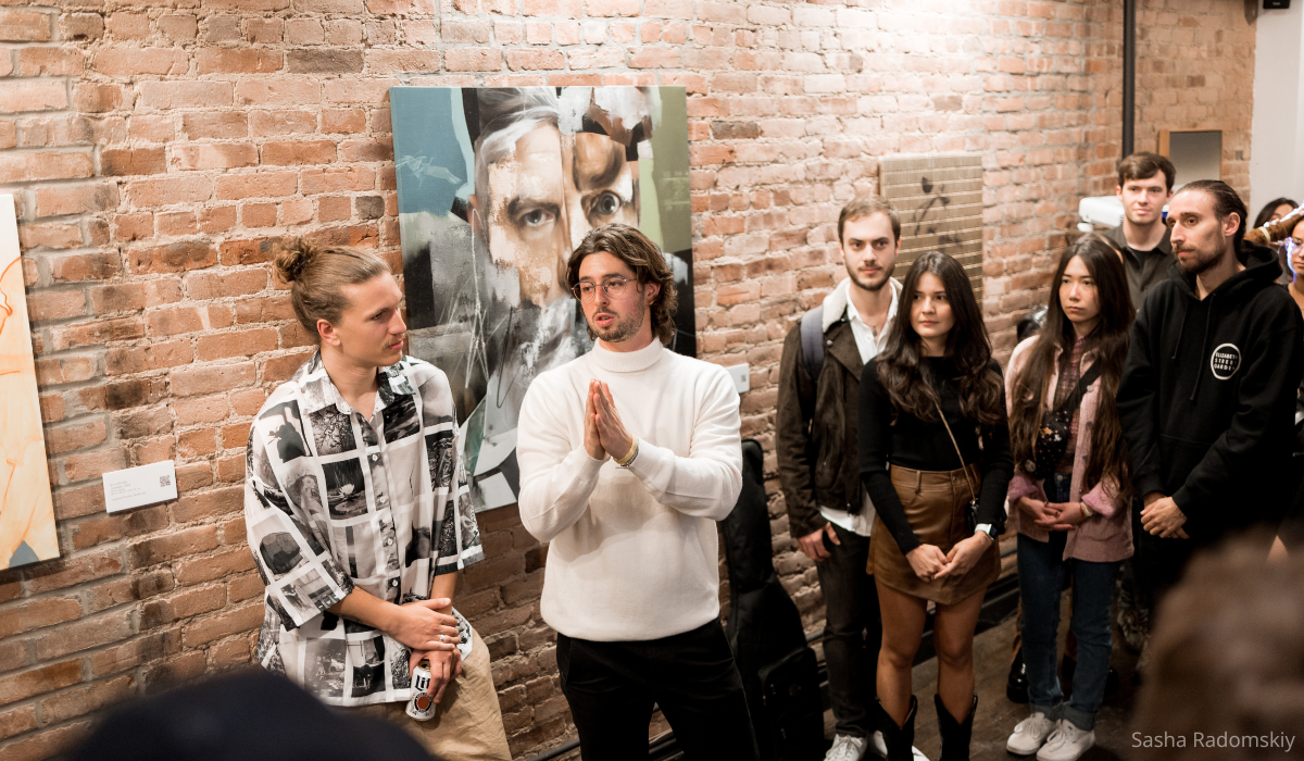 Dustin J Ross, founder of Sunflower Network at a fundraising exhibit surrounded by patrons.