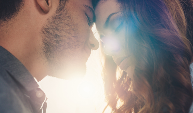 A couple leans their heads together.