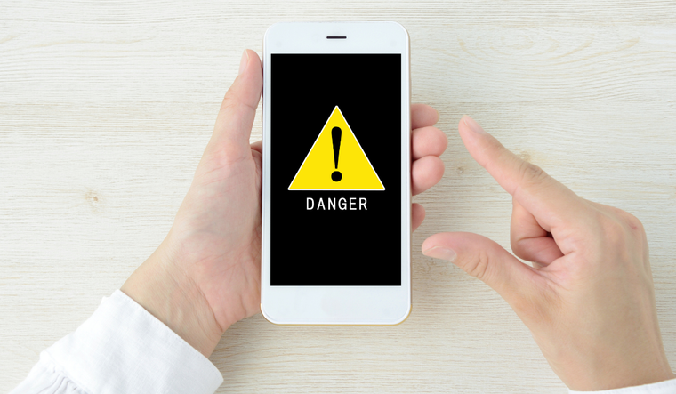 Hand with cell phone with danger warni