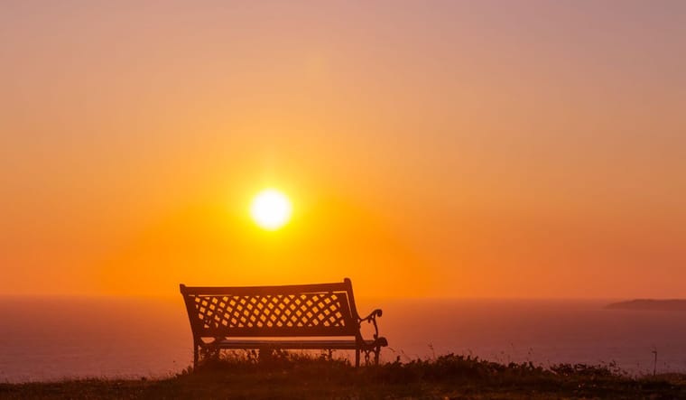 Sunrise and a bench on a mountain.