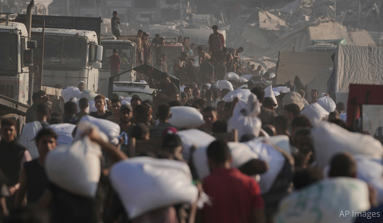 Palestinians carry sacks of flour unloaded from a humanitarian aid convoy that reached Gaza City from the northern Gaza Strip.