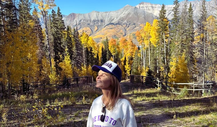 Maria enjoys nature with mountains behind her.