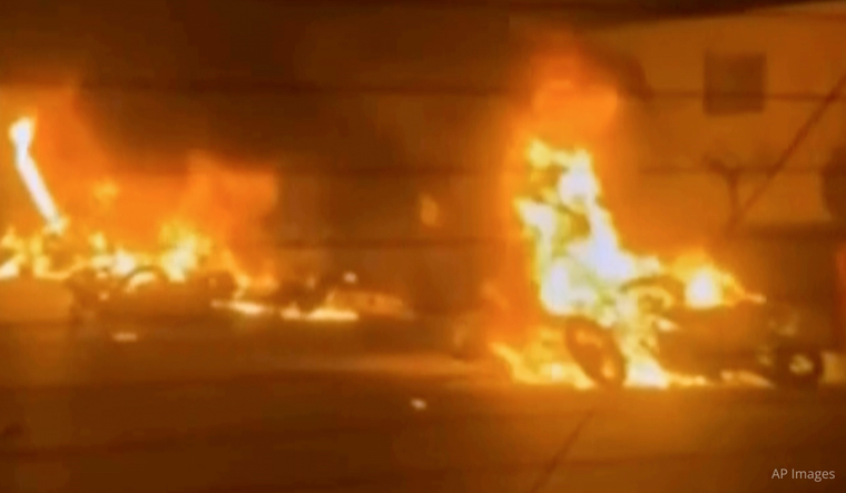 This frame grab from a video released by Iran state TV shows vehicles burning amid night of mass protests in Tehran, Iran, Thursday, Jan. 8, 2026.