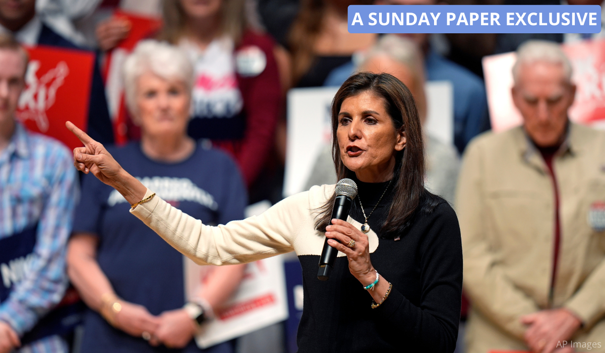 Nikki Haley gives a campaign speech with supporters behind her.